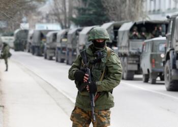 FILE PHOTO: Armed servicemen wait in Russian army vehicles outside a Ukranian border guard post in the Crimean town of Balaclava March 1, 2014. REUTERS/Baz Ratner/File Photo