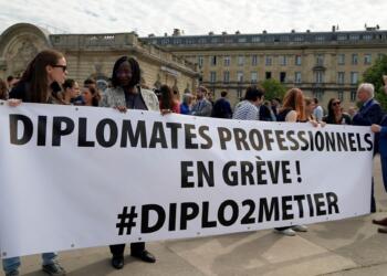 Diplomats hold a banner reading "Professional diplomats on strike" during a protest near the French Foreign Ministry Thursday, June 2, 2022 in Paris. Members of the French diplomatic corps are dropping their traditional reserve to go on a rare strike, angered by a planned reform they worry will hurt their careers and France's standing in the world. (AP Photo/Nicolas Garriga)