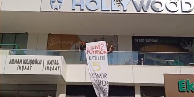 Kadınlar adliye karşısındaki binaya Deniz Poyraz pankartı astı