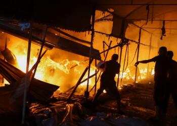People attempt to extinguish a fire at the site of an Israeli strike on tents sheltering displaced people, amid the Israel-Hamas conflict, in Deir Al-Balah in the central Gaza Strip, October 14, 2024. REUTERS/Ramadan Abed