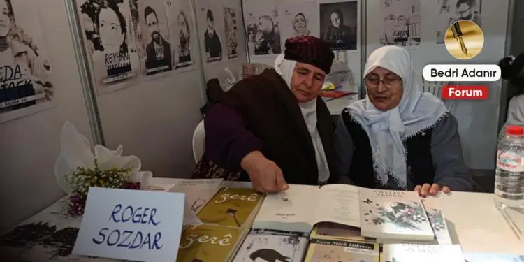 Kitap fuarında beyaz tülbendiyle bir anne