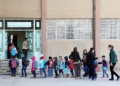 Jana Musa, a 21-year old Kurdish language teacher, leads her students into the building at the Musa Bin Nusayr school in the northeastern Syrian city of Qamishli, on February 1, 2016. The Kurdish language was once banned by the government in Damascus, but now the local semi-autonomous government has rolled out an entire curriculum for primary school students in Kurdish in parts of the territory under its control. (Photo by DELIL SOULEIMAN / AFP)