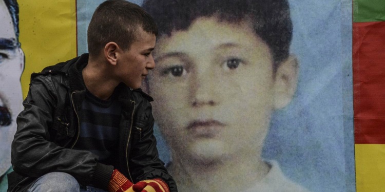 TOPSHOTS
Kurds pose with pictures A friend of 12-year-old boy Nihat Kazanhan (R), who was allegedly shot dead by police in the Cizre district of Sirnak on January 14, mourns on January 15, 2015 in Sirnak. Prime Minister Prime Minister Ahmet Davutogu and the interior minister have denied any police involvement regarding the death of the child.     AFP PHOTO / ILYAS AKENGIN